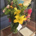there is a vase of flowers on a glass table in a living room