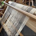 there is a weaving machine with a purple yarn on it