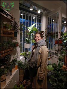 there is a woman standing in a room with lots of plants