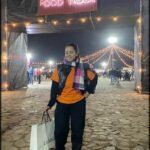 there is a woman standing in front of a food truck