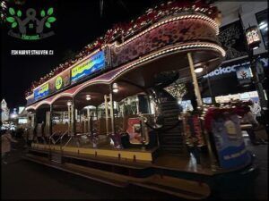 A beautifully decorated trolley car is parked at night, ready to take passengers on a magical journey.