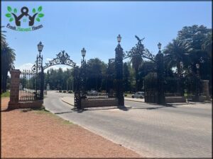 A black iron gate with a bird on top of it.