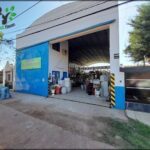 A blue garage door is open, revealing a storage area filled with various items.