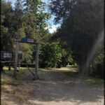 A dirt pathway leads to a wooden sign that reads "La Laguna".