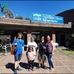 A group of people, including a man and a woman, pose for a picture in front of a building.