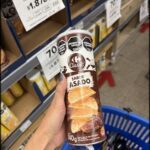 A person holding a can of Sabro Asado chips.