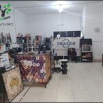 A room with a Traeer sign on the wall and a table with a laptop and a mouse on it.