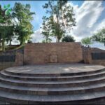 A stone monument with a brick circle in front of it.