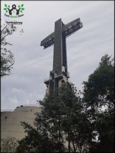 arafed cross on top of a building with trees in front of it