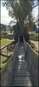 araffe bridge over a grassy area with benches and trees