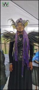 araffe dressed in a costume with feathers and a purple scarf