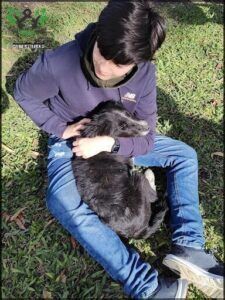araffe sitting on the ground with a dog in his lap