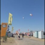 people are flying kites in the sky at a festival