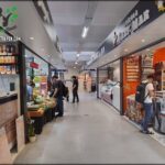 people are shopping in a store with a variety of food items