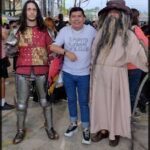 several people in costumes are standing around a man in a costume