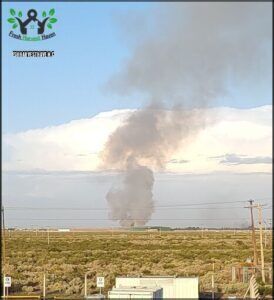 smoke billowing out from a large plume in the distance