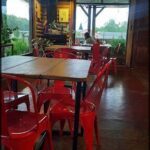 tables and chairs in a restaurant with a view of the mountains