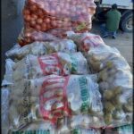 there are many bags of onions on a pallet in the street
