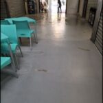 there are many chairs in the hallway of a building with a person walking by
