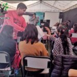 there are many people sitting in chairs in a room
