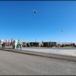 there are many people walking on the street with kites in the sky