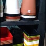 there are many pots and containers on a shelf in a room