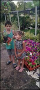 there are two children standing in a garden with flowers