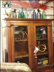 there is a cabinet with glass bottles on top of it