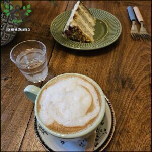 there is a cup of coffee and a piece of cake on a table