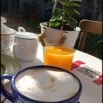there is a cup of coffee and a plate of food on a table