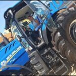 there is a man driving a tractor with a large tire
