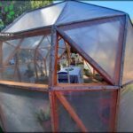 there is a small greenhouse with a table and chairs in it