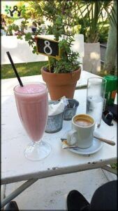 there is a table with a drink and a cup of coffee on it