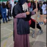 there is a woman in a costume holding a baby in a market