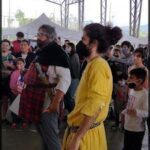 there is a woman in a yellow dress standing next to a man in a yellow shirt