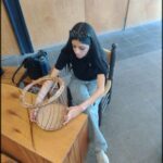 there is a woman sitting on a chair with a basket on her lap