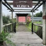 there is a wooden walkway leading to a building with a sign