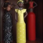 Three figurines of women are standing next to each other.