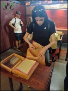 woman in black shirt and black shorts standing over a table with a bag