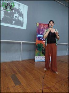 woman standing in front of a projector screen giving a presentation