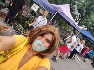 woman with a face mask taking a selfie with her dog