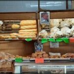 A bakery display case filled with a variety of breads and pastries.