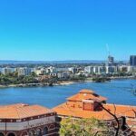 A beautiful cityscape with a large body of water, a city skyline, and a clear blue sky.