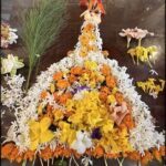 A beautiful floral arrangement is displayed on a table, featuring a variety of flowers and plants.