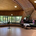 A birthday celebration is taking place in a room with a brick wall and a wooden ceiling.