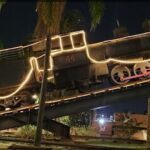 A black train with the number 44 on the front is sitting on a track.