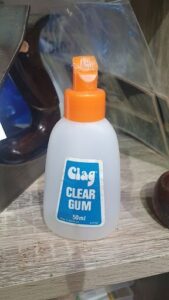 A bottle of clear gum sits on a table.