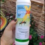 A bottle of insecticide is being held by a person.
