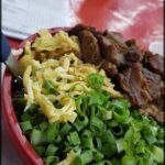 A bowl of food with a spoon in it.