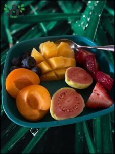 A bowl of fruit with a spoon in it.